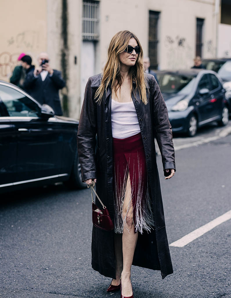 Woman wearing a white blouse, mini black skirt and a Givenchy Voyou bag 